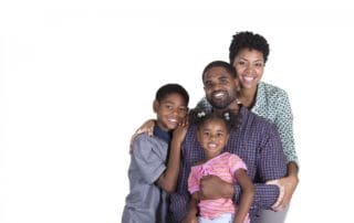 A family posing with bright smiles, showcasing the aesthetic services of family dentistry at Pike District Smiles.