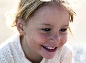 Kid girl smiling, showcasing her healthy teeth at Pike District Smiles.
