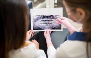 Dentist showing dental x-rays to a patient at Pike District Smiles.