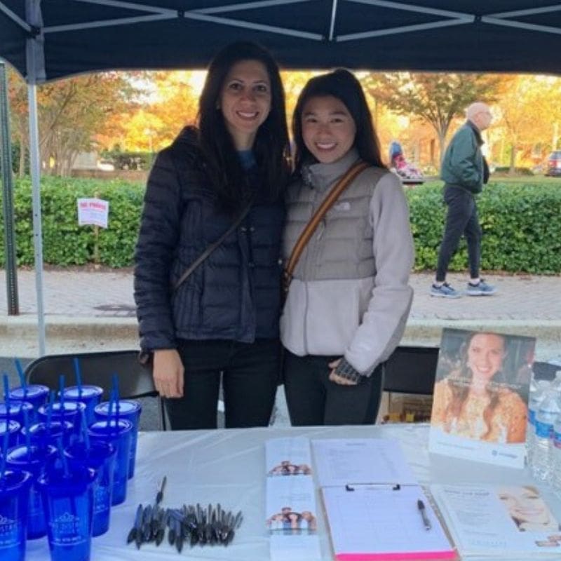 Dr. Samia Nikkhah posing with a teen girl at a running event.