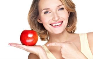 Woman holding an apple in her hand.