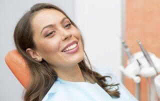 Satisfied patient smiling at the clinic after treatment.