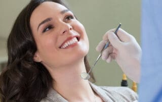 Female smiling with wide-open face, displaying her white teeth during dental examination.