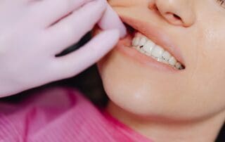 Dentist using gloved hand to open patient's mouth for dental examination.
