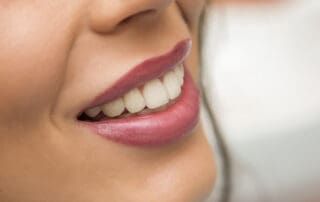 Satisfied patient displaying her perfect, shiny white teeth.