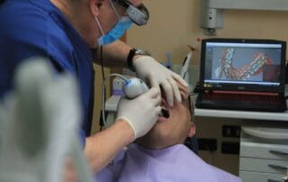 Dentist placing dental instrument in the mouth of the patient during dental treatment.