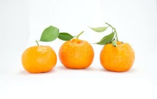 Three oranges placed on a table.